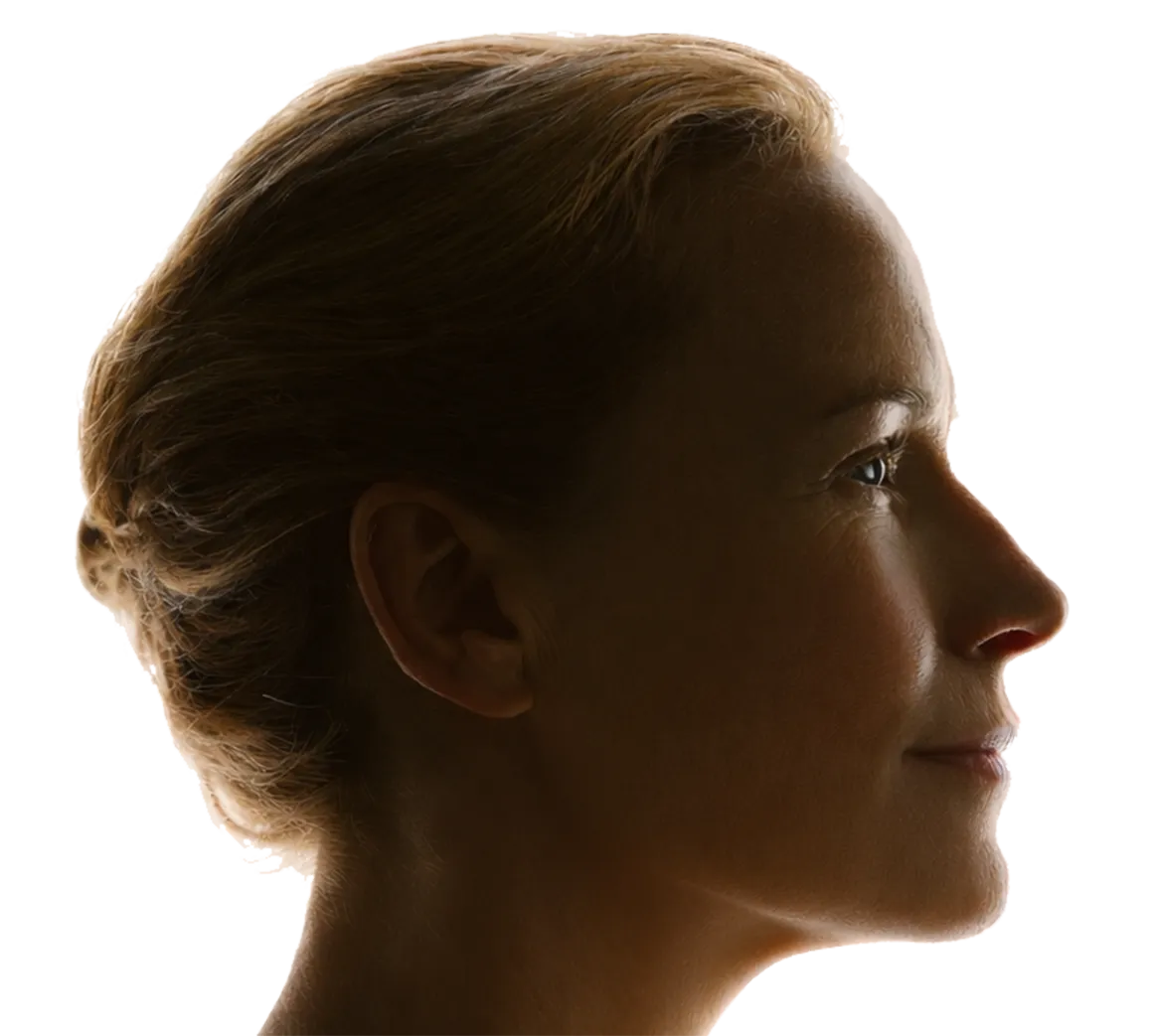 Close-up side profile of a woman with blonde hair pulled back, looking forward with a calm expression.
